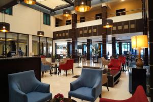 a lobby of a hotel with chairs and tables at MENA Tyche Hotel Amman in Amman