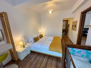 um quarto com uma cama com uma mesa de cabeceira e uma cama sidx sidx sidx em Holiday Apartment em Ghimbav