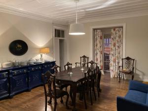 une salle à manger avec une table, des chaises et une armoire bleue dans l'établissement Junqueira Gardens - Casa Antiga Jardim e Piscina, à Lisbonne