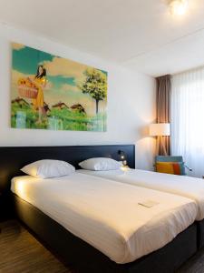 um quarto com uma cama grande e uma pintura na parede em Hotel Alkmaar em Alkmaar