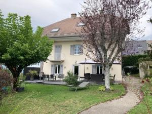 ein großes weißes Haus mit einem Tisch und Stühlen in der Unterkunft Villa Evalou de 240 m². in Trévignin