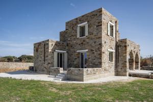 a stone house in the middle of a field at Stone Haven Villas in Plaka