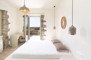 a white room with a bed and a window at Stone Haven Villas in Plaka