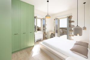 a bedroom with green cabinets and a white bed at Stone Haven Villas in Plaka +30 photos