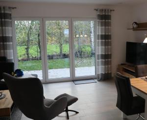 an open living room with sliding glass doors at Ferienhaus Dorie in Dornumersiel