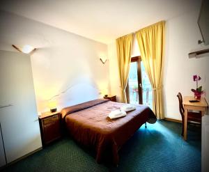 a bedroom with a bed with two towels on it at Hotel Pinguino in Pescasseroli