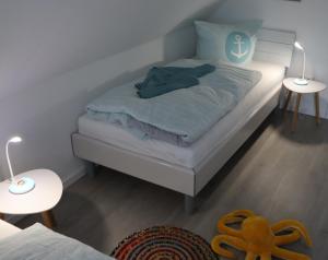 a bedroom with a bed with two tables and two lamps at Ferienhaus Dorie in Dornumersiel