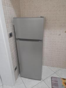 a white refrigerator in a room with a tile wall at Casa Brezza marina in Barletta