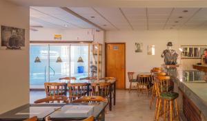 a restaurant with tables and chairs and a window at Hotel de Cine Las Golondrinas in Villa Gesell