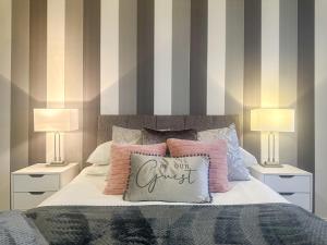 um quarto com uma cama com almofadas e 2 candeeiros em Luxury Suite in Colchester Town Centre By Station em Colchester