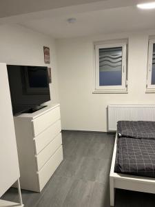 um quarto com uma cama e uma televisão numa cómoda em Home for You- Monteurwohnung Ferienwohnung 2 