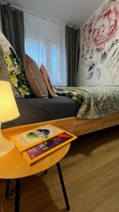 een slaapkamer met een bed en een tafel met een boek erop bij Gajowa Apartament in Chorzów