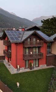 a red house with solar panels on the roof at Al Bait Ross in Bormio