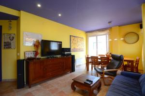 uma sala de estar com um sofá azul e uma televisão em PORT 23 ATIC em L'Estartit