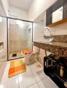 a bathroom with a shower and a toilet and a sink at Otima casa proxima a praia do Acuipe em Ilheus BA in Ilhéus