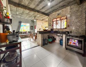 a large kitchen with a stove top oven in a room at Otima casa proxima a praia do Acuipe em Ilheus BA in Ilhéus