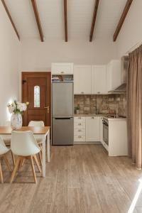 eine Küche mit einem Tisch und einem Kühlschrank in der Unterkunft Apolis Villas & Suites Resort in Parga