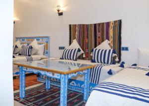 a room with two beds and a glass table at CASA BLUE PEARL in Chefchaouen