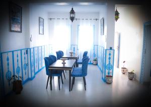 a dining room with a table and blue chairs at CASA BLUE PEARL in Chefchaouen