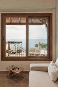 una sala de estar con una gran ventana con vistas al océano en Apolis Villas & Suites Resort, en Parga