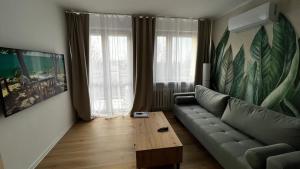 - un salon avec un canapé et une table basse dans l'établissement Gajowa Apartament, à Chorzów