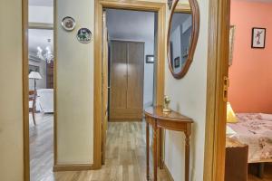 pasillo con puerta, mesa y espejo en Apartamento Carlos-1, en Madrid
