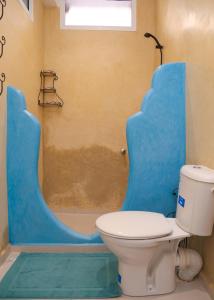 a bathroom with a toilet and a shower with a tub at CASA BLUE PEARL in Chefchaouen