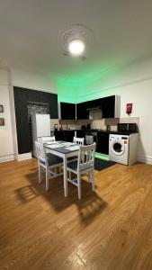 a kitchen with a table and chairs in a room at Willesden Guest Room 130 in London