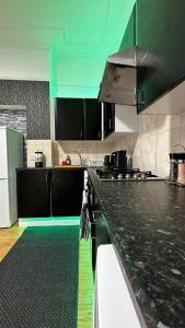 a kitchen with black counter tops and green ceilings at Willesden Guest Room 130 in London