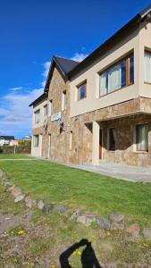 a building with a shadow of a person on the grass at KILKA's in Caviahue