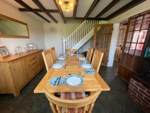 a dining room with a wooden table with blue dishes on it at Cherry Garth in Sleights