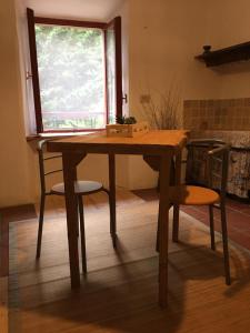 uma mesa de madeira com 2 cadeiras e uma janela em B&B Il Mulino alla Busa em Vallarsa
