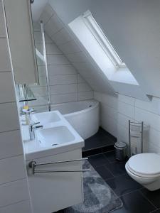 ein weißes Bad mit einem Waschbecken und einem WC in der Unterkunft Sky in Winterberg