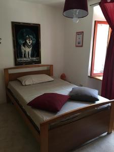 a bed in a bedroom with a dog picture on the wall at B&B Il Mulino alla Busa in Vallarsa