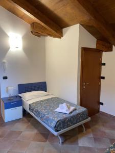 Habitación pequeña con cama y techo de madera. en Cascina Boschetti, en Barolo