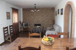 un salon avec une table et un salon avec une cheminée dans l'établissement CASA ENCINA, à Tolox