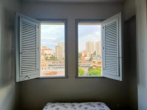 two windows in a room with a view of a city at Apartamento vista praça estação Centro BH in Belo Horizonte