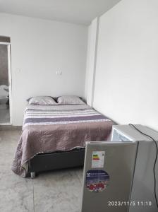 ein Schlafzimmer mit einem Bett und einem TV davor in der Unterkunft HOSPEDAJE Derrama Magisterial in Chiclayo