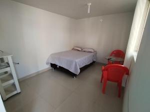 ein Schlafzimmer mit einem Bett und zwei roten Stühlen in der Unterkunft HOSPEDAJE Derrama Magisterial in Chiclayo