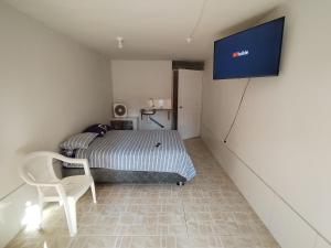 ein Schlafzimmer mit einem Bett und einem TV an der Wand in der Unterkunft HOSPEDAJE Derrama Magisterial in Chiclayo