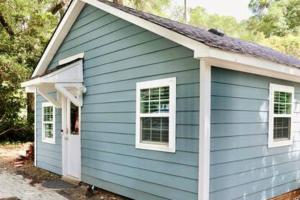 una casa azul con una puerta y ventanas blancas en Coastal Golf Hideaway, en Wilmington
