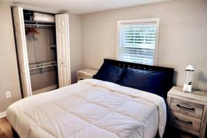 Un dormitorio con una gran cama blanca y una ventana en Coastal Golf Hideaway, en Wilmington