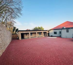 un vialetto di mattoni rossi di fronte a un edificio di The Curve Apartments Unit 15 a Johannesburg