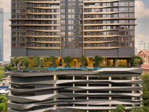 un grand bâtiment avec des arbres sur son côté dans l'établissement 8 Kia Peng Suites KLCC by Luna, à Kuala Lumpur