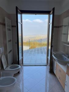 a bathroom with a toilet and a view of a balcony at Cascina Boschetti in Barolo +87 photos