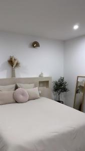a white bedroom with a large white bed with pillows at La Suite du clocher in Noves