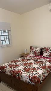 1 dormitorio con 1 cama con edredón de flores en Superbe appartement T3 à Pamandzi, en Pamandzi