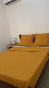 1 cama con edredón amarillo y 2 almohadas en Superbe appartement T3 à Pamandzi, en Pamandzi