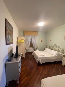 a bedroom with two beds and a television in it at AL MANDORLO Casa Vacanze in Viterbo
