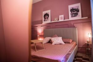 ローマにあるDomus Febo-Telesio Suiteのベッドルーム1室(壁に2枚の写真が飾られたベッド1台付)